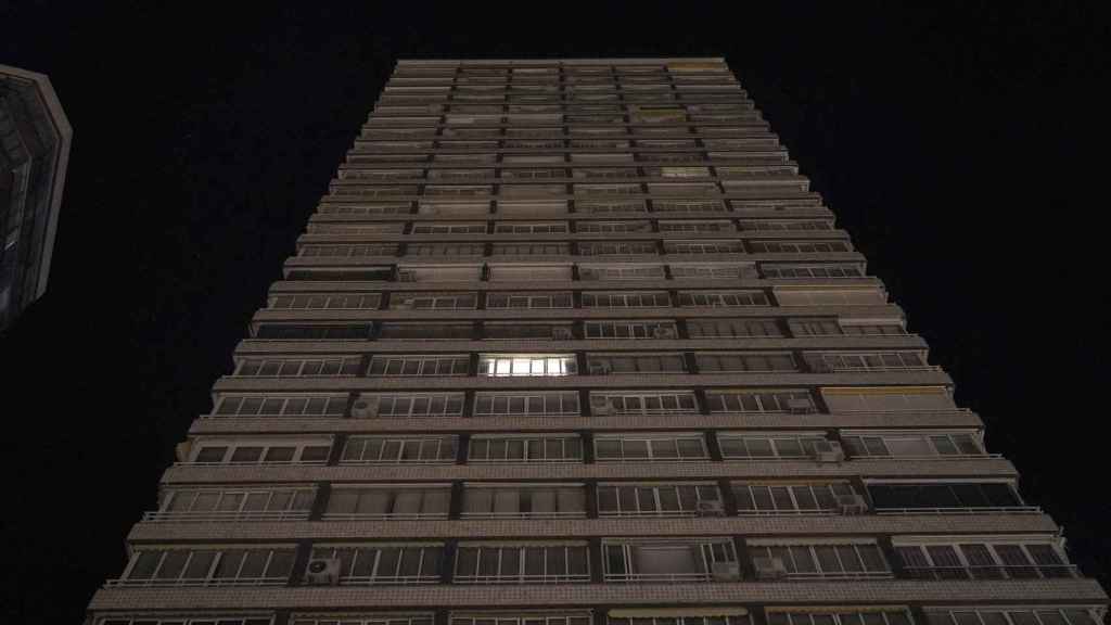 Una sola luz encendida en una torre de apartamentos a pie de playa, en Benidorm.