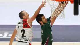 Lanzamiento a canasta de Axel Bouteille ante Jonathan Rouselle, en el Unicaja - Bilbao Basket
