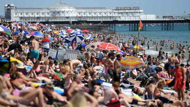 Cientos de personas disfrutan de una calurosa jornada en la playa en Brighton (Reino Unido), este jueves.