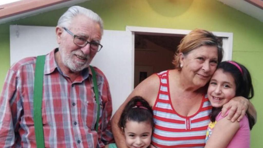 Ricardo y Mercedes con sus nietas delante de la casa que les han construido.