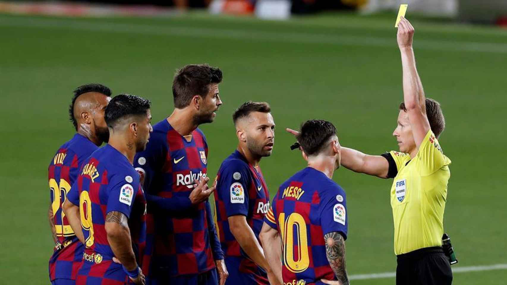Hernández Hernández enseña la tarjeta amarilla a Gerard Piqué por las protestas en el Barcelona - Atlético de Madrid