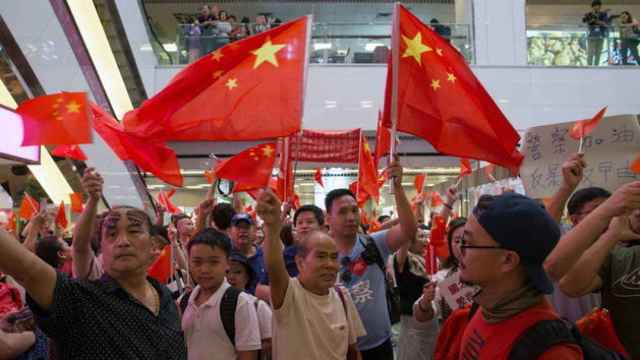 Varios ciudadanos chinos sostienen banderas del país.
