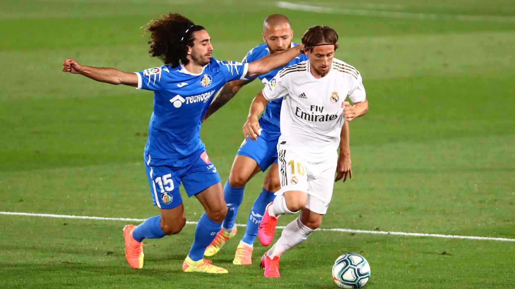 Luka Modric perseguido por dos jugadores del Getafe