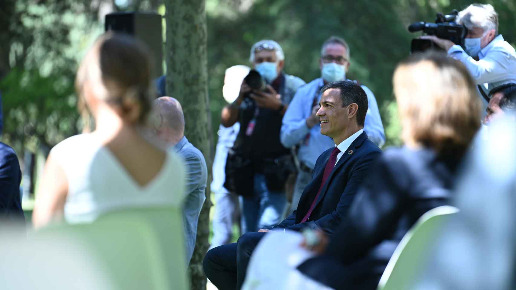 Pedro Sánchez, en los jardines de Moncloa, y la ministra Yolanda Díaz desenfocada y de espaldas.