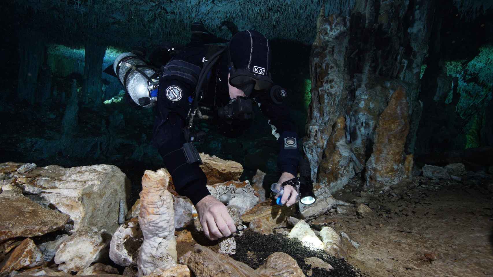 Buceador toma muestras de carboncillo en el lugar donde se ha hallado la mina de ocre más antigua de las Américas en Yucatán (México).
