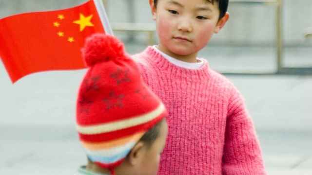 Un menor pasea con su familia en el centro de Pekín.
