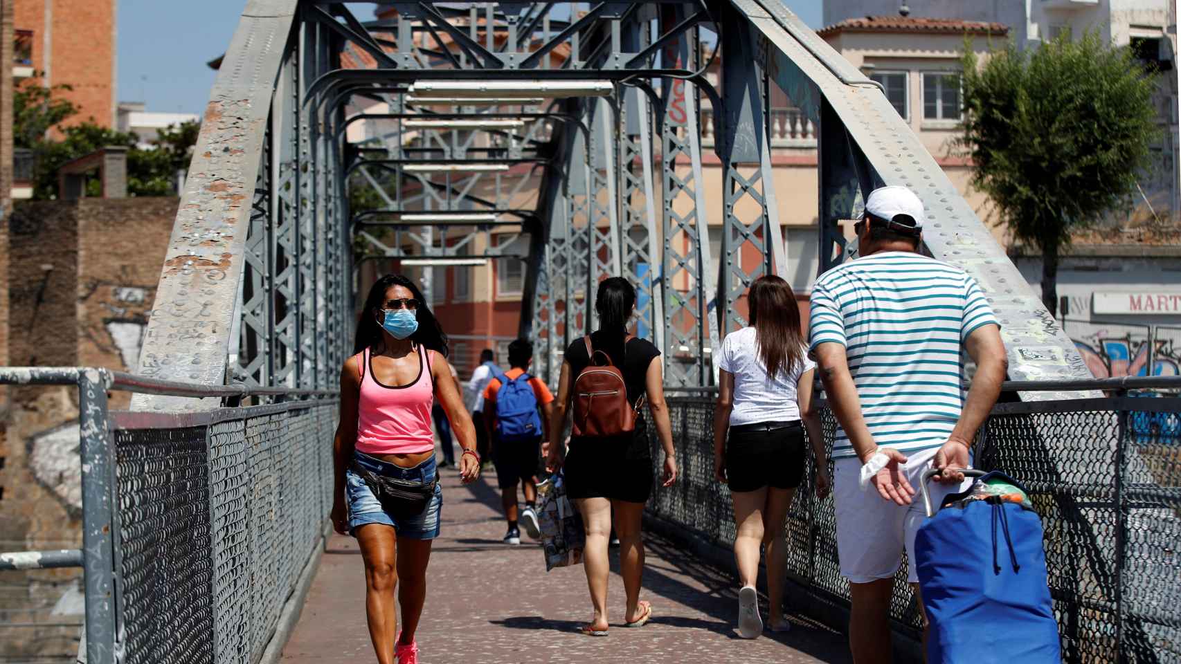 Unos vecinos cruzan el puente de la Torrassa, este sábado, en Hospitalet de Llobregat.