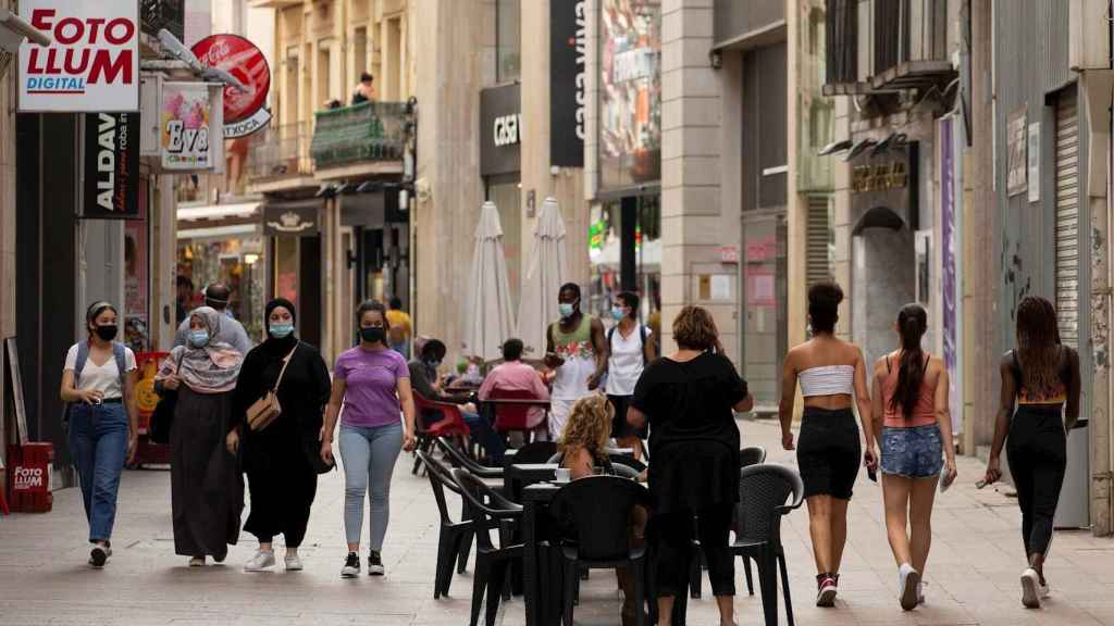 Varias personas caminan por el centro comercial e histórico de Lleida. EFE/Enric Fontcuberta