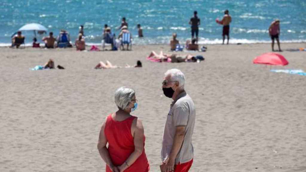 Un matrimonio usa la mascarilla en una playa de Almería.