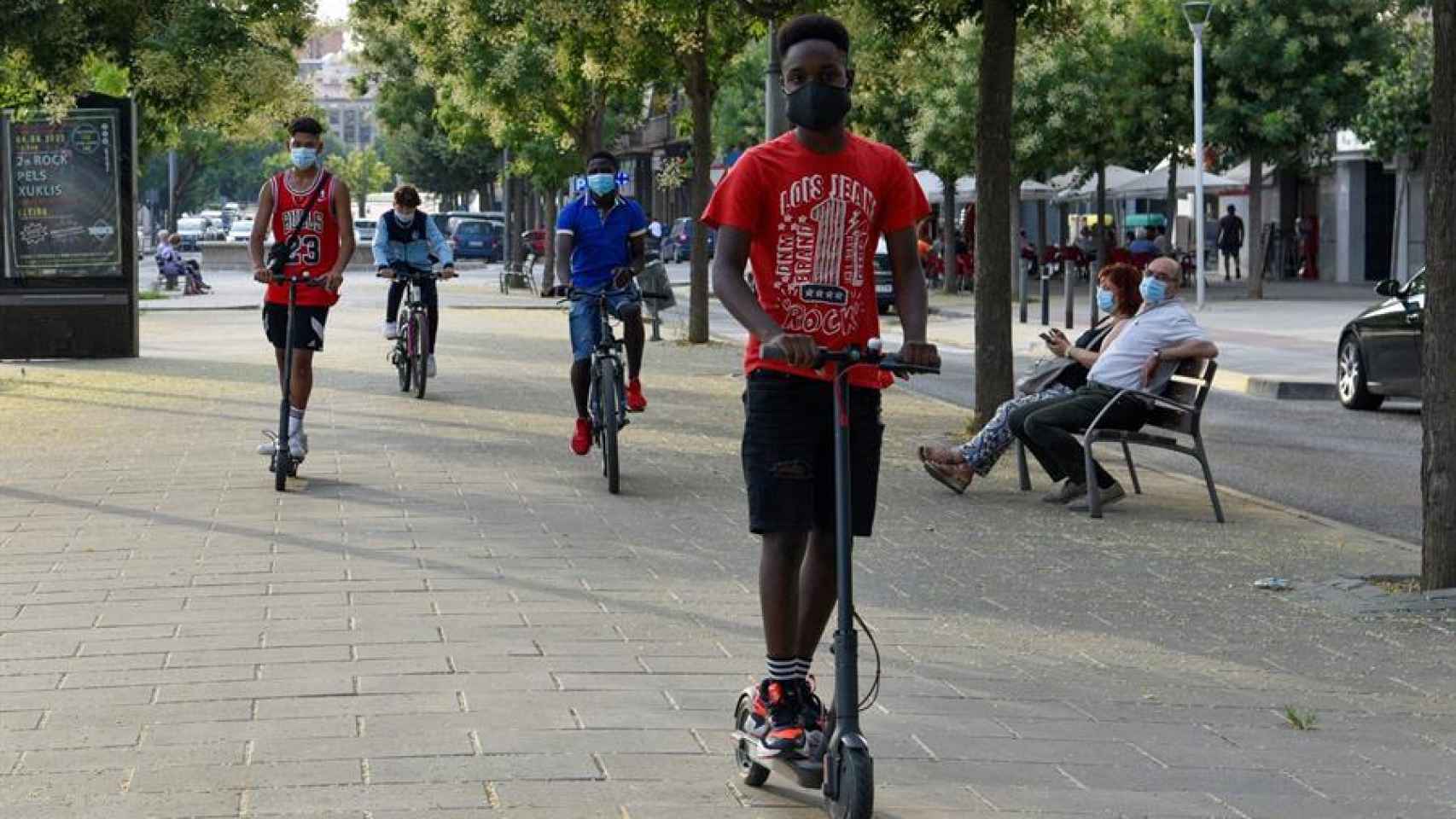 Jóvenes pasean en bicicleta y en patinete este martes en el barrio de Cap Pont, Lleida.