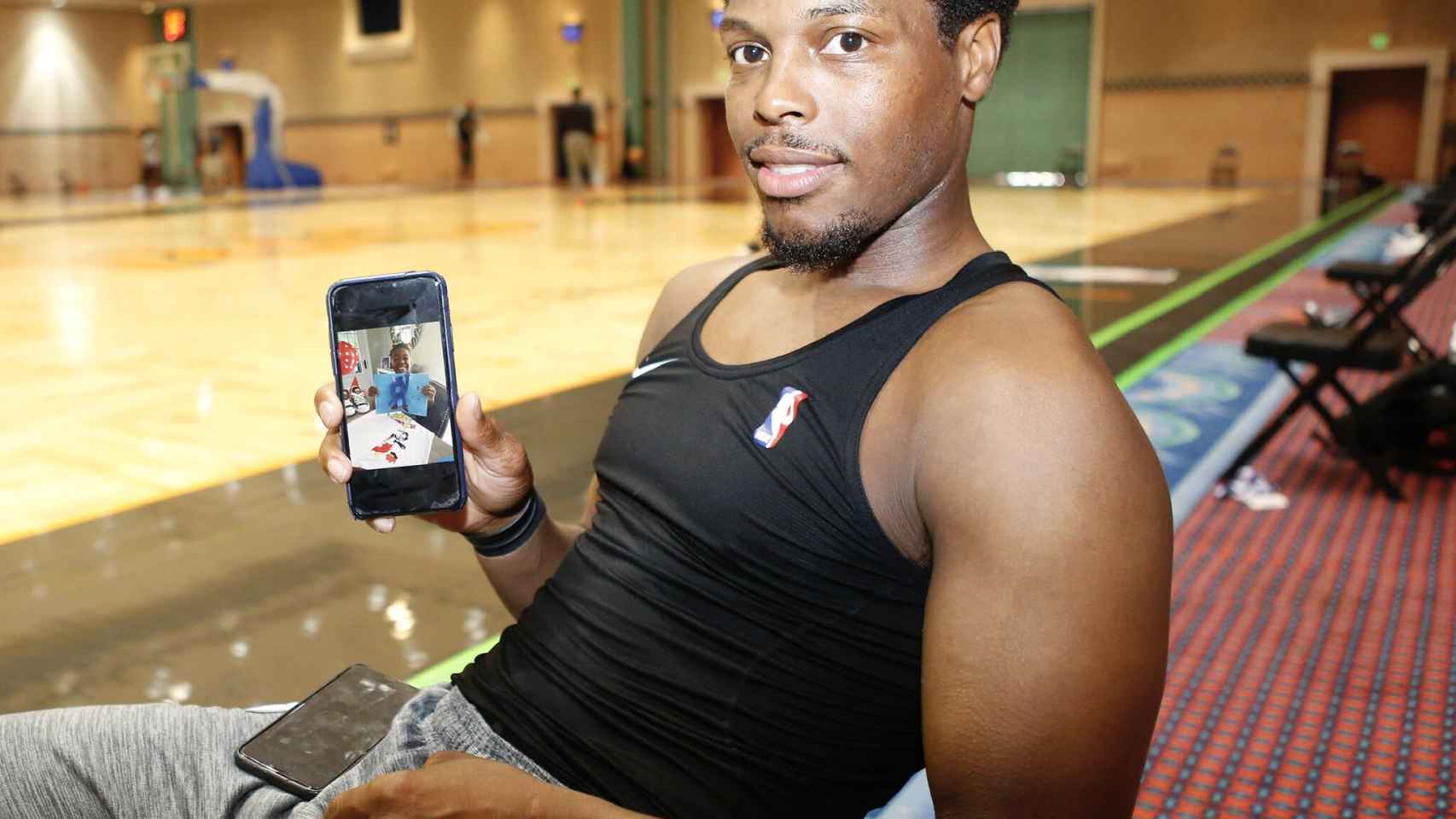 Kyle Lowry, jugador de los Raptors de la NBA, sosteniendo un móvil