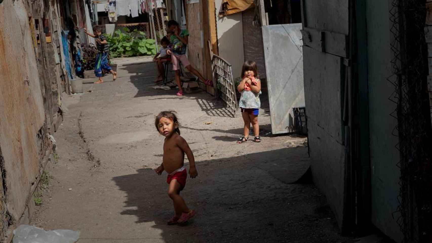 Dos niños juegan entre las viviendas improvisadas en un terreno ocupado en Caracas.