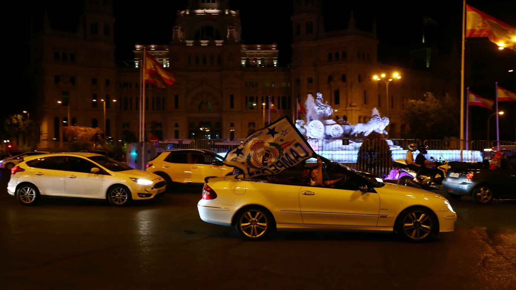 Aficionados del Real Madrid celebran el título de Liga a su paso en coche por La Cibeles