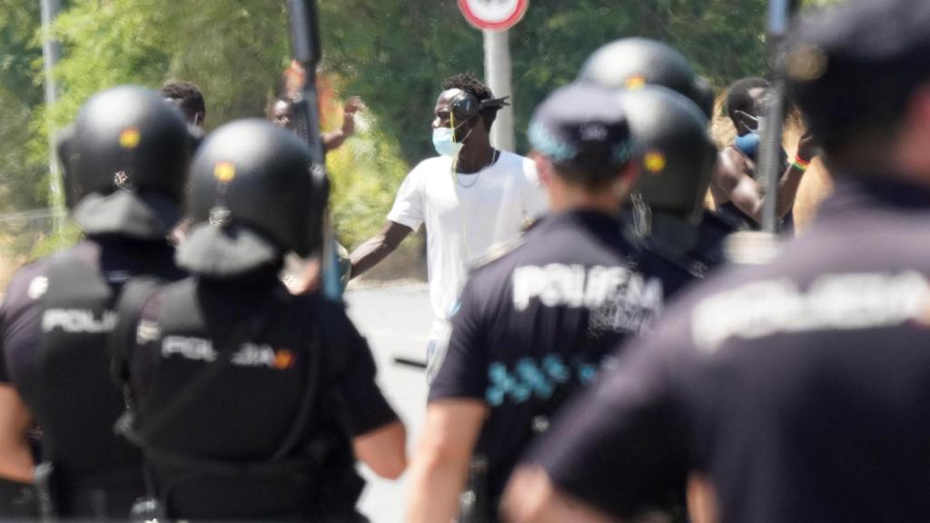 Antidisturbios y agentes de la Policía Nacional, frenando la protesta de los inmigrantes.