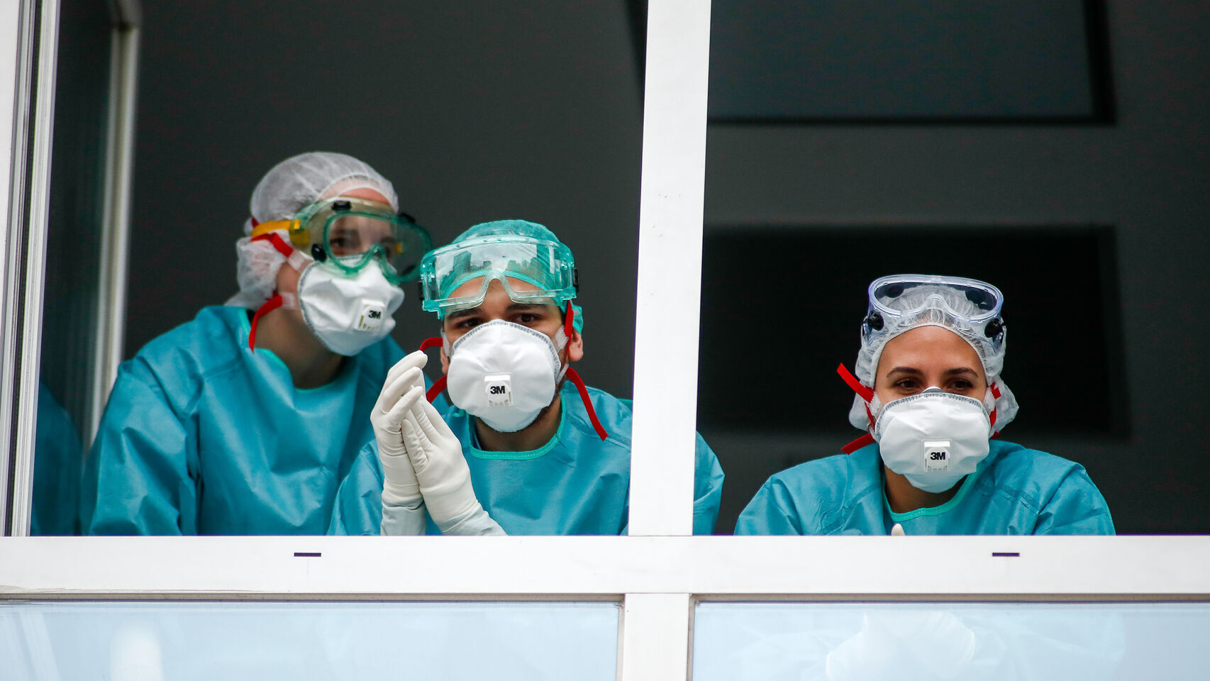 Unos sanitarios mirando desde la ventana de un hospital español.