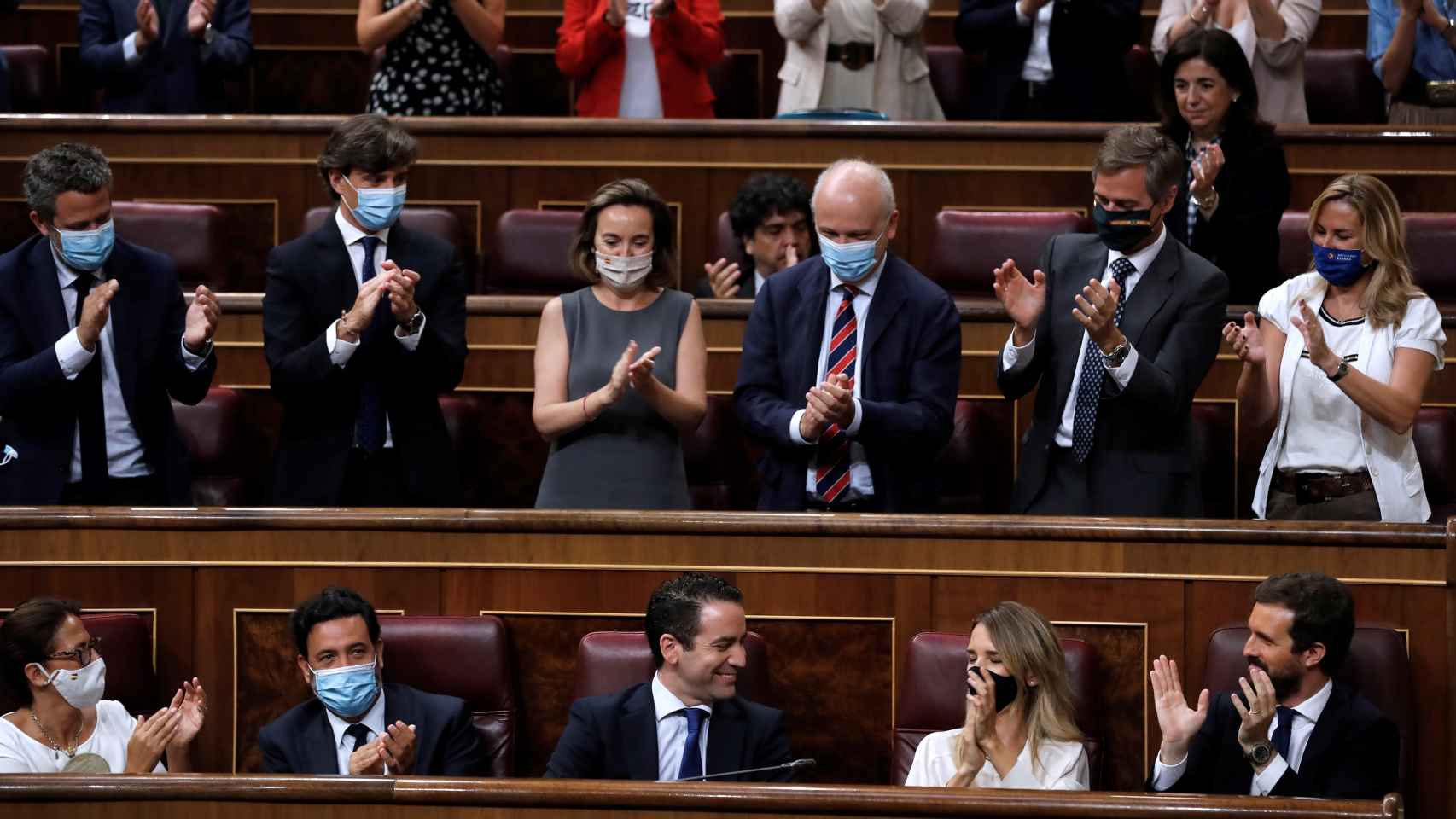 La bancada del PP aplaude a Teodoro García Egea tras su intercambio con Pablo Iglesias.