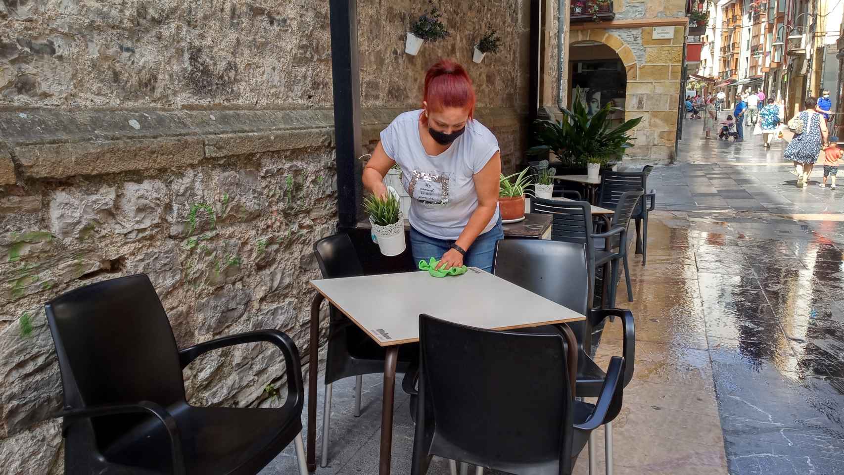 Una trabajadora desinfecta la mesa de una terraza en Ermua, Vizcaya.
