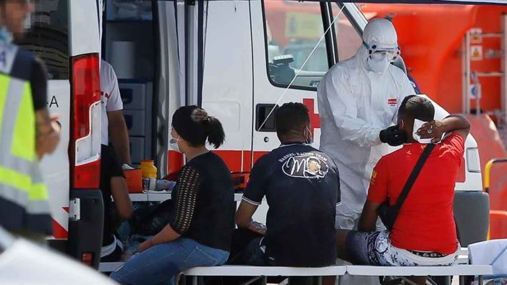 Sanitarios de la Cruz Roja atienden a varios inmigrantes que han sido interceptados tras alcanzar tierra en Alicante.