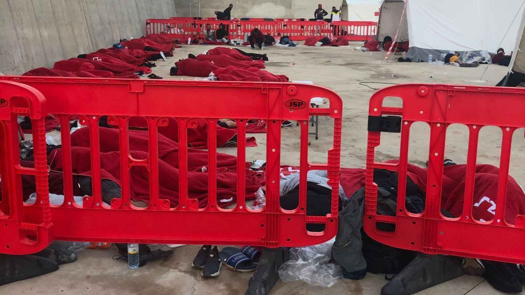 Decenas de inmigrantes argelinos durmiendo pegados en el suelo pese a los riesgos de contagios por Covid.