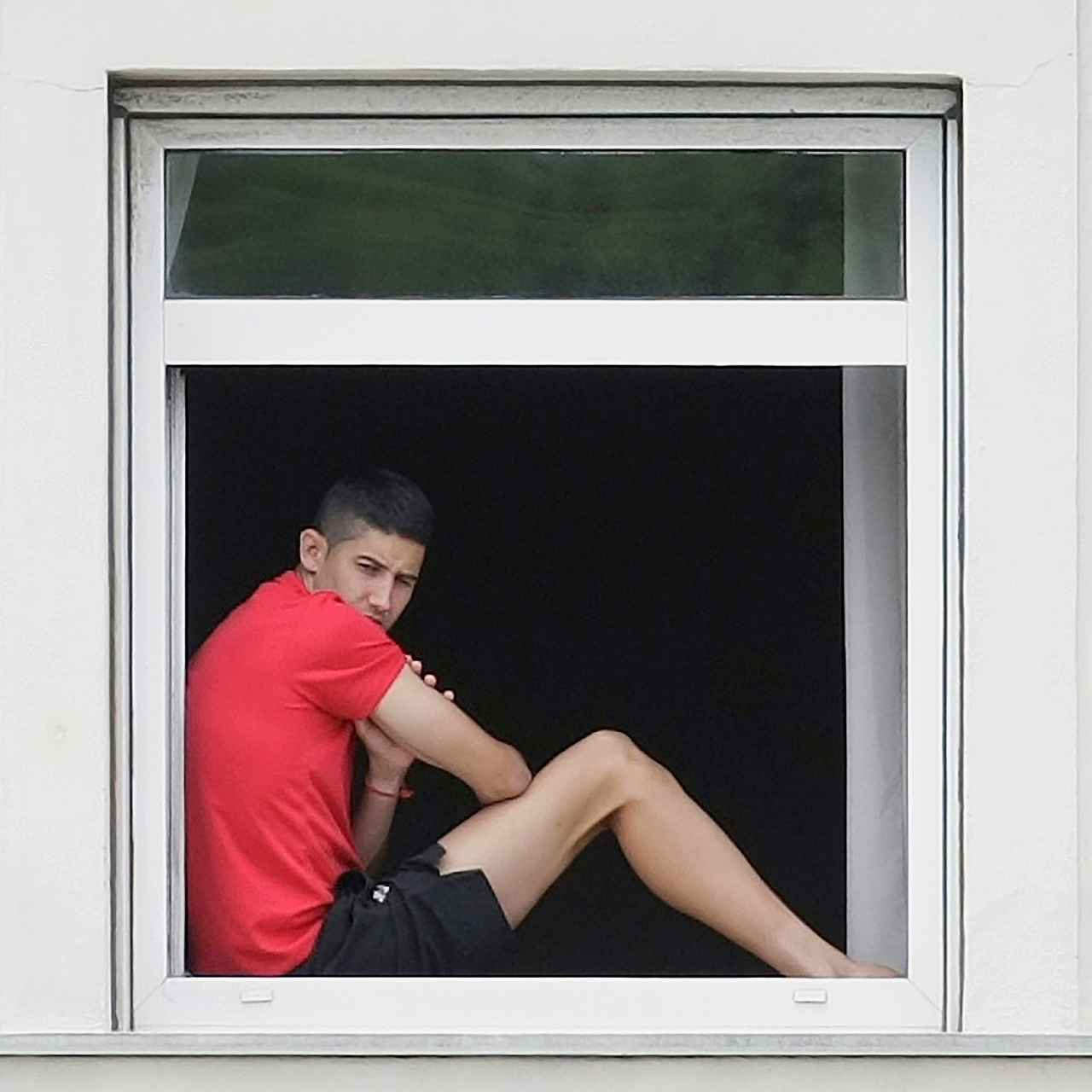 Jugador del CF Fuenlabrada en la ventana de hotel donde están confinados