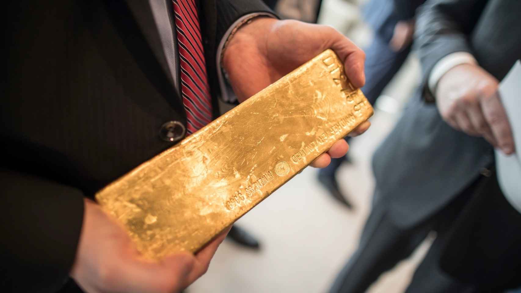 Un inversor sostiene un lingote de oro.