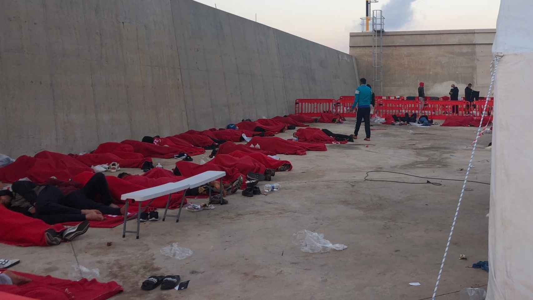 Decenas de inmigrantes argelinos durmiendo en el suelo porque el campamento del puerto de Escombreras no tenía camas.
