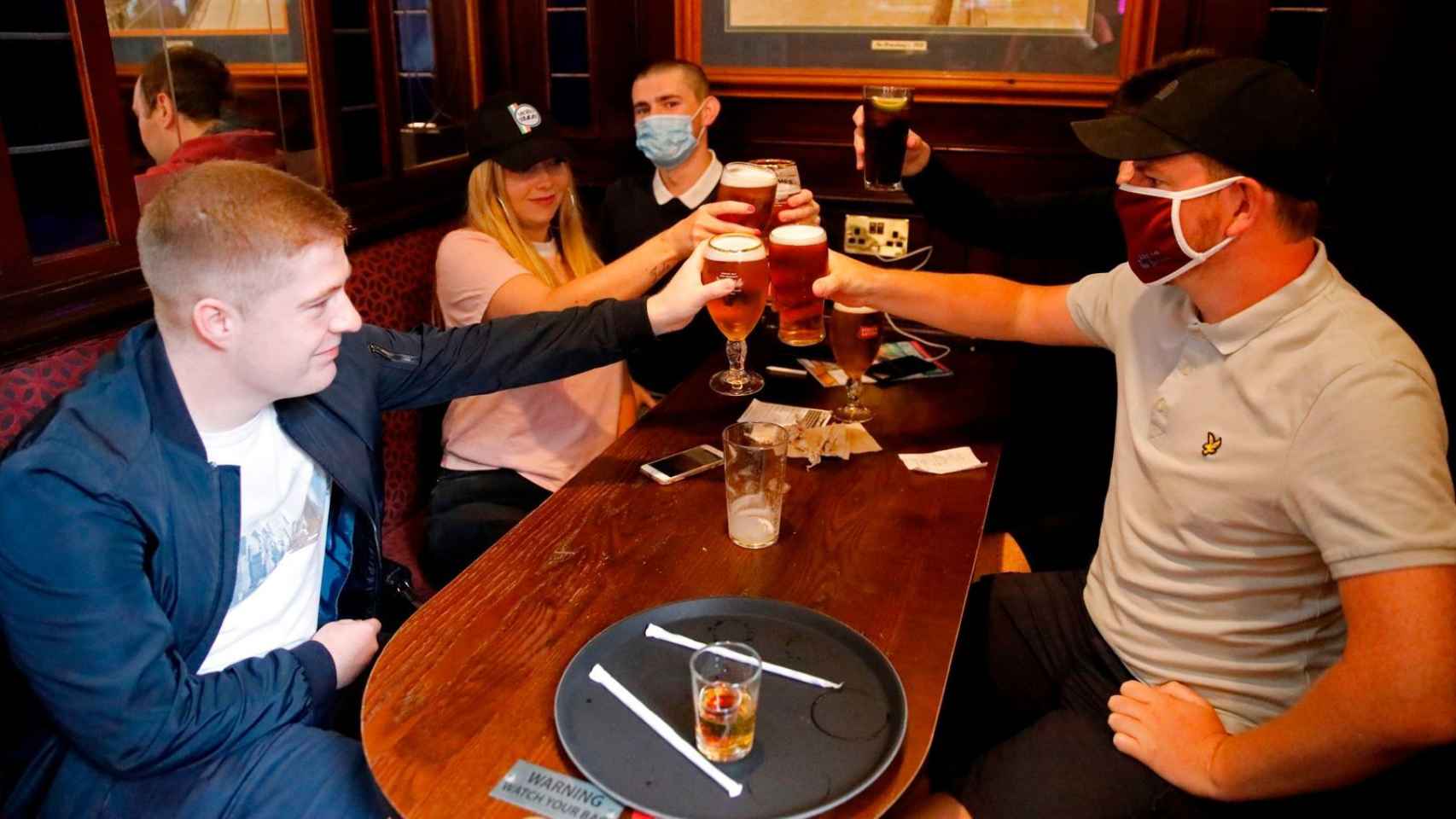 Unos clientes llevan mascarillas dentro de un pub en Londres.