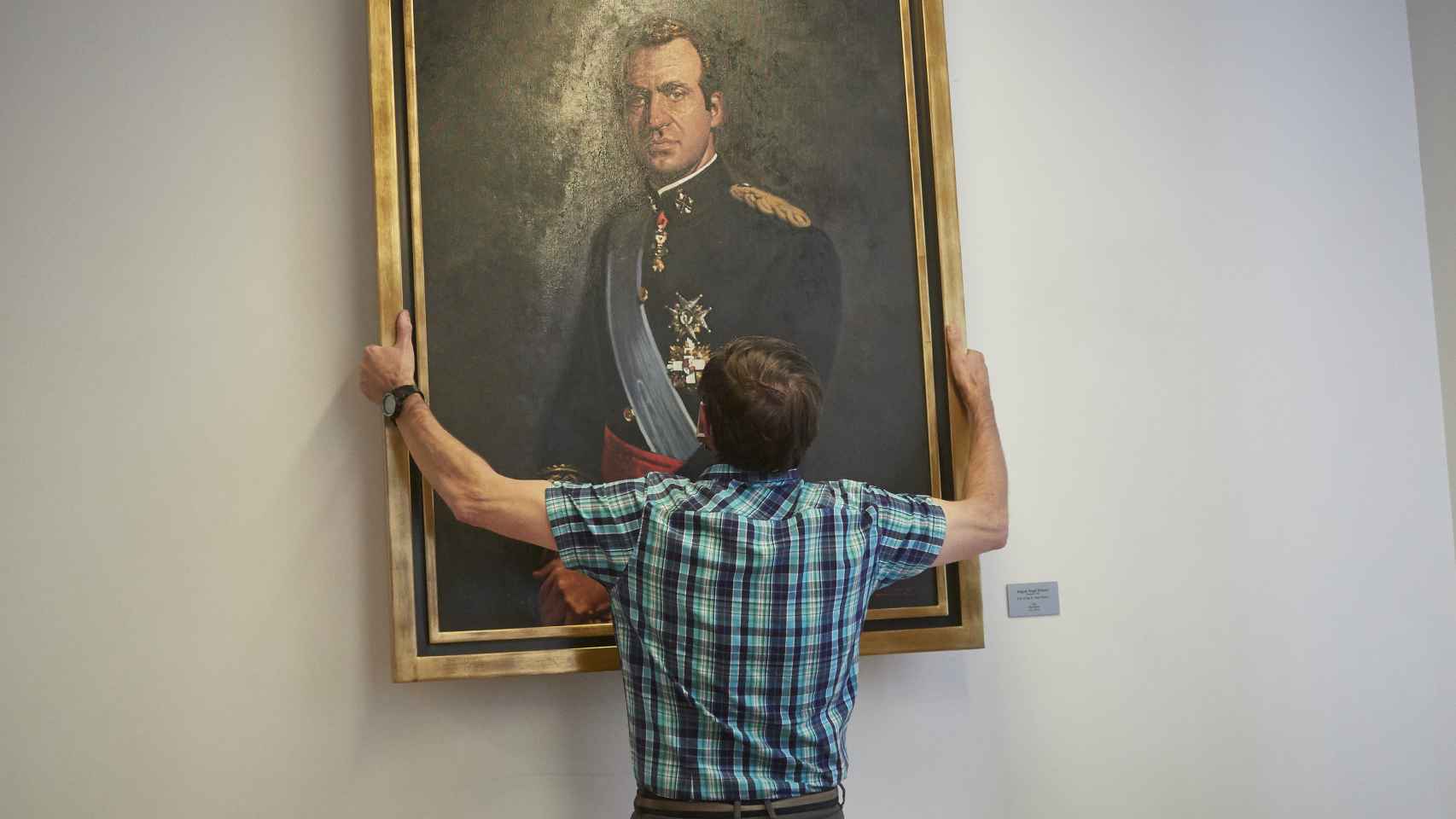 Un operario retira el retrato del rey emérito Juan Carlos I de la Sala de Gobierno del Legislativo foral del Parlamento de Navarra.