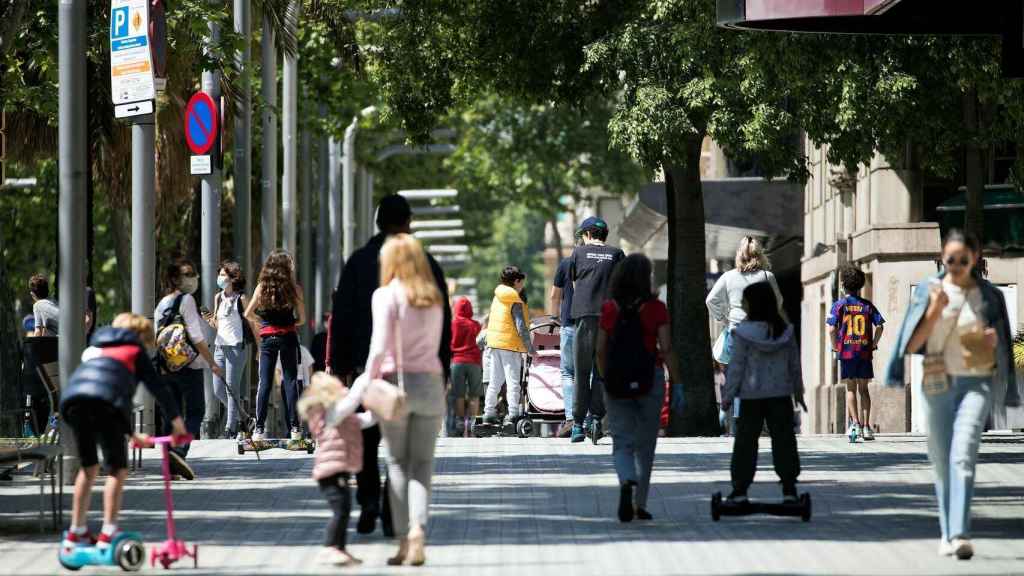 Varias familias pasean con sus hijos en la Diagonal de Barcelona.
