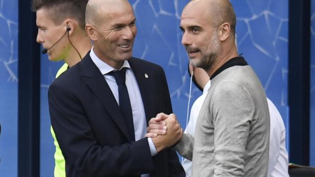 Zinedine Zidane y Pep Guardiola se saludan antes del inicio del partido entre el City y el Real Madrid