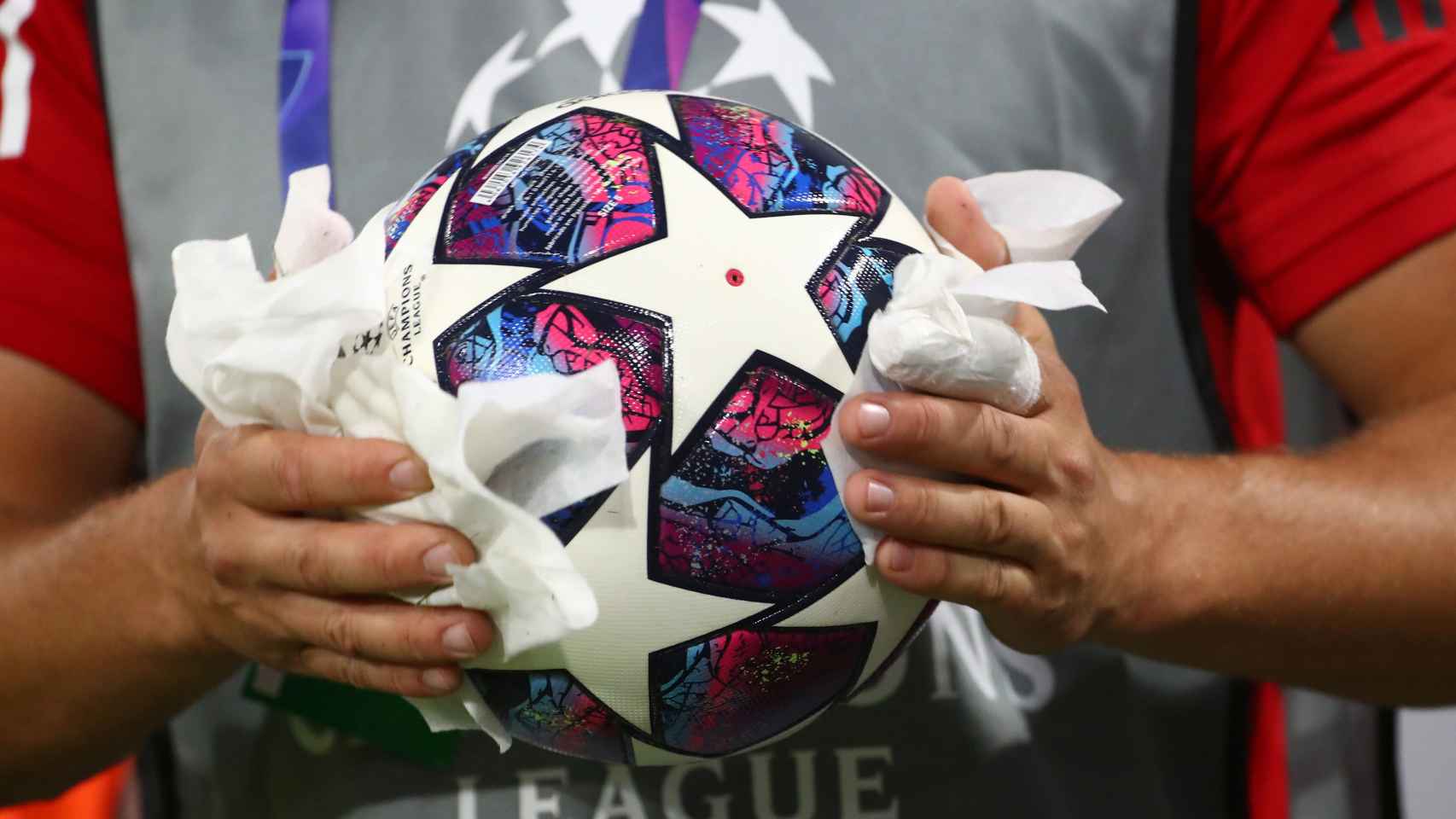 Un recogepelotas desinfecta un balón de la Champions League