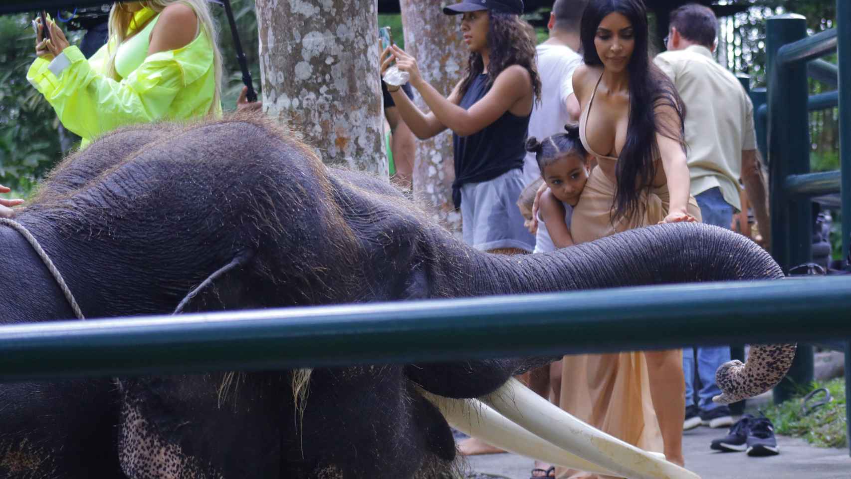 Kim Kardashiam y su hija visitando a un elefante.