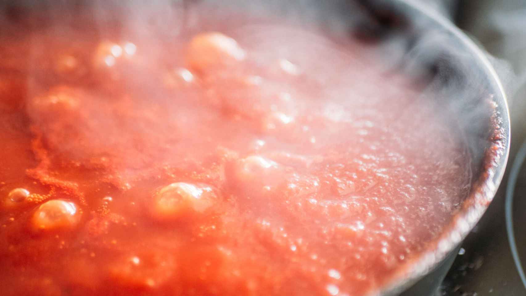 Una salsa de tomate bullendo en la cazuela.