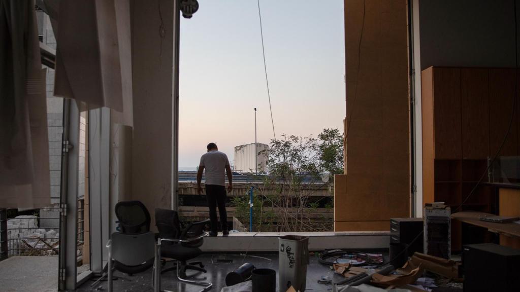 Un hombre dentro de un edificio destruido por la explosión en Beirut.