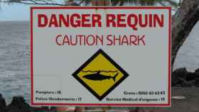 Cartel alertando del peligro de tiburones en una playa de la isla de La Reunión, Francia.