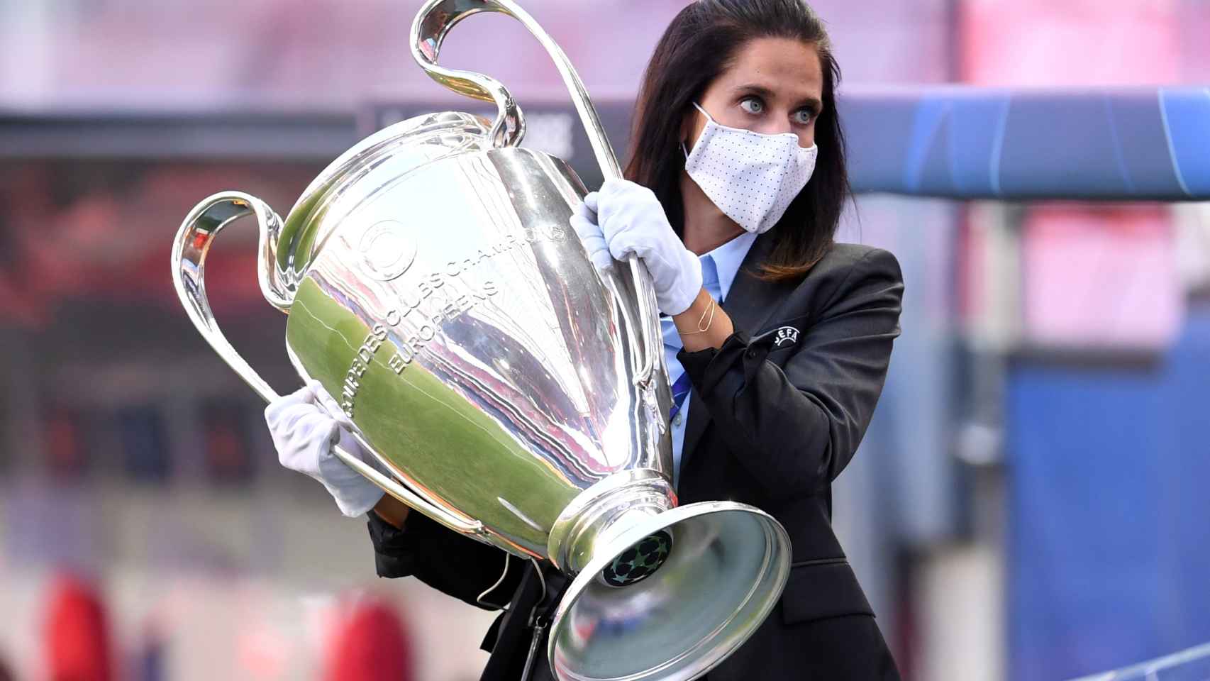 Un miembro de la organización traslada el trofeo de la Champions League
