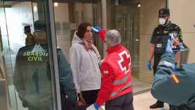 Un miembro de Cruz Roja toma la temperatura a una turista.