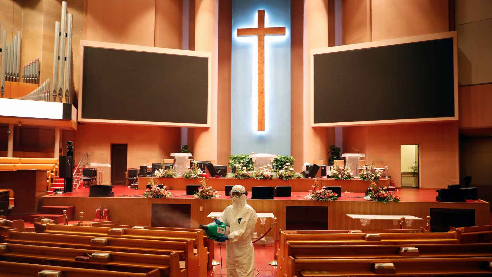 Un trabajador desinfecta la una de las iglesias del Amor Máximo.