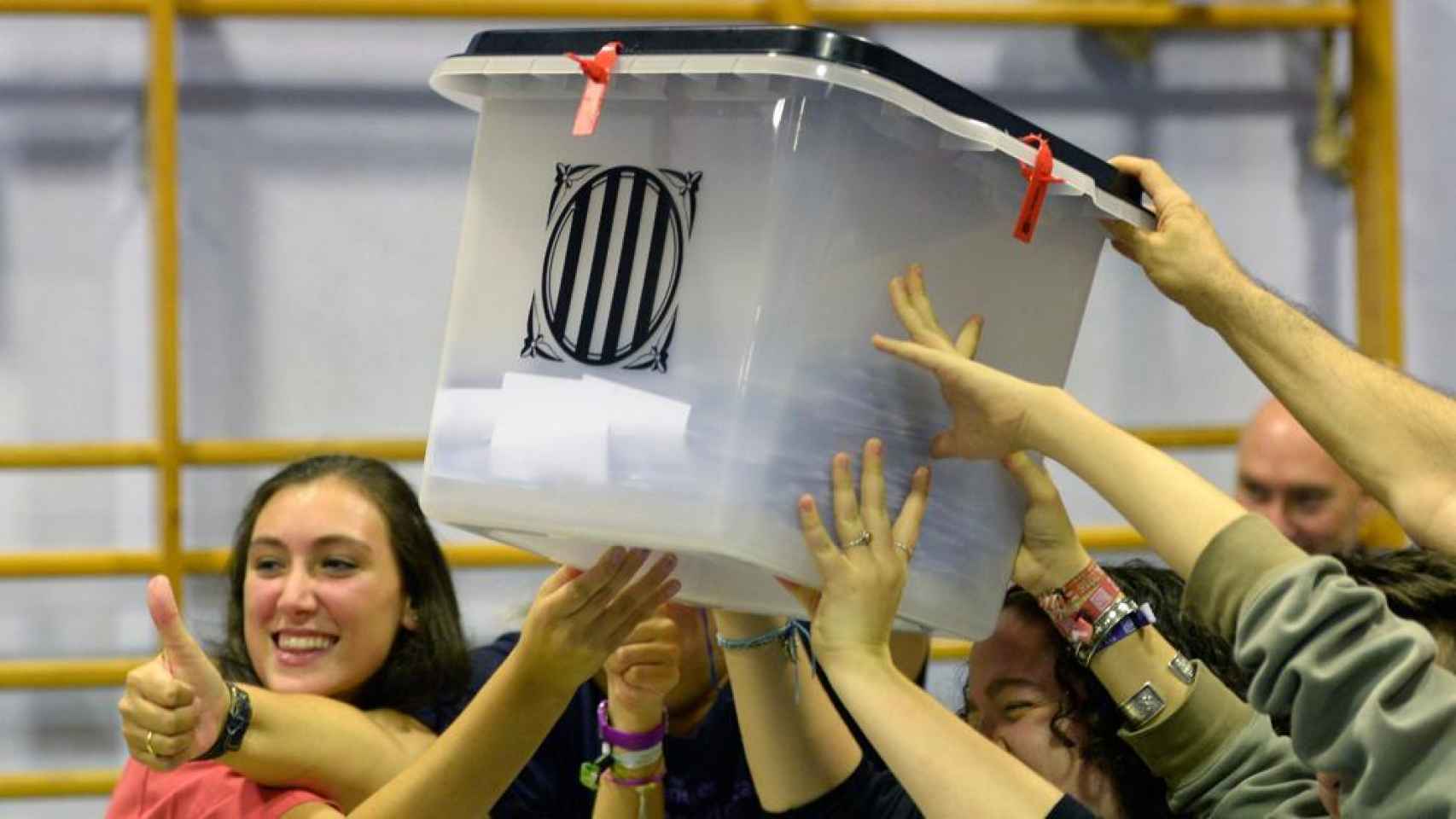 Un grupo de personas levanta una urna durante el referéndum del 1 de octubre de 2017 en Cataluña.