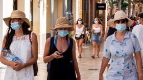 Tres mujeres con mascarilla pasean por Menorca.