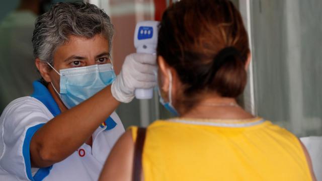 Una trabajadora de Sanidad toma la temperatura a varias personas en un hospital de Móstoles