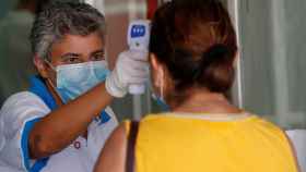 Una trabajadora de Sanidad toma la temperatura a varias personas en un hospital de Móstoles