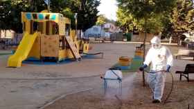 Un operario fumigando un parque infantil en Palomares del Río.