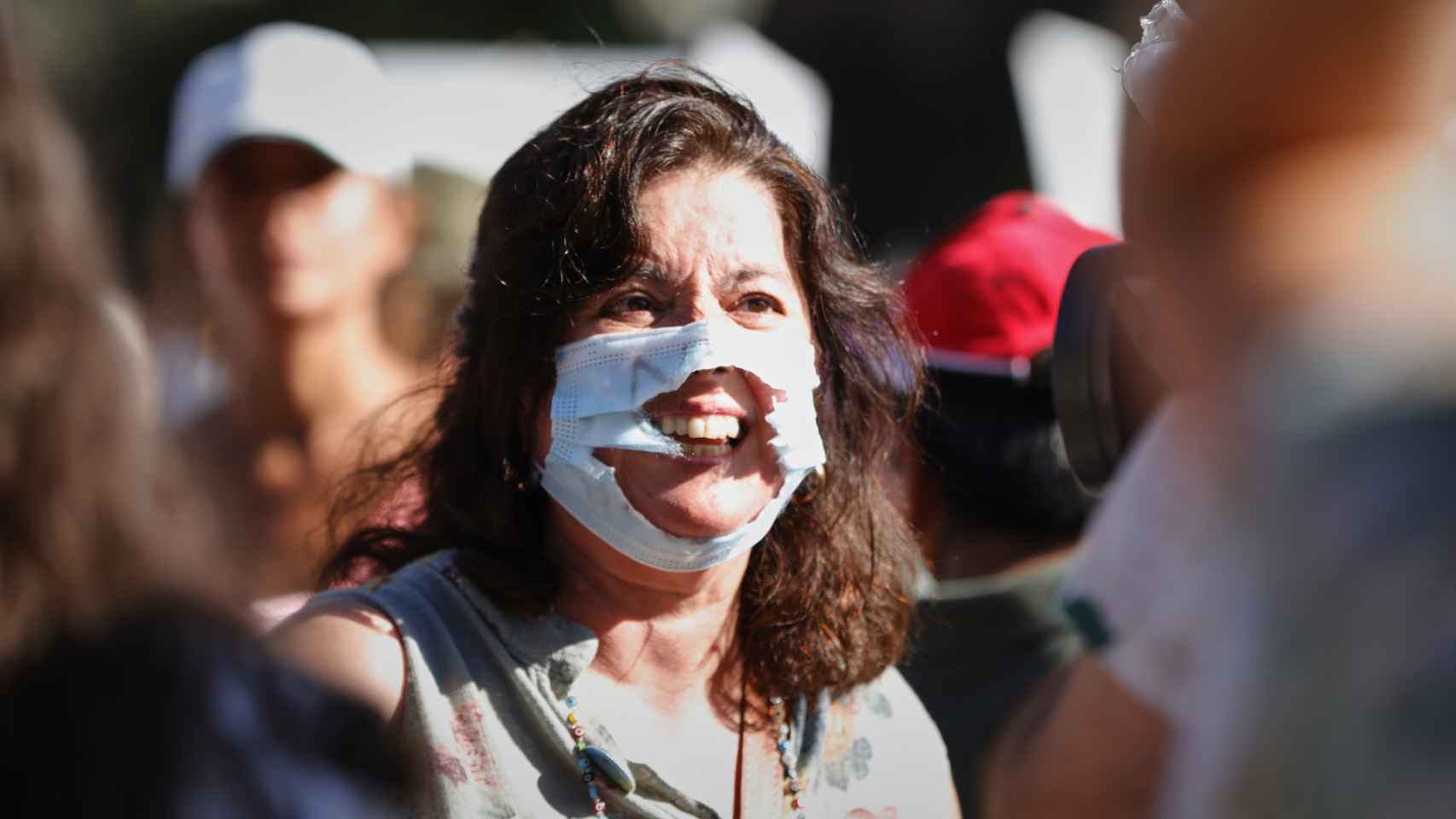 Una mujer, con la mascarilla rota, en el concentración negacionista de la plaza de Colón, Madrid.