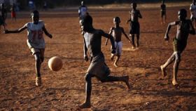 Niños jugando al fútbol en un país africano