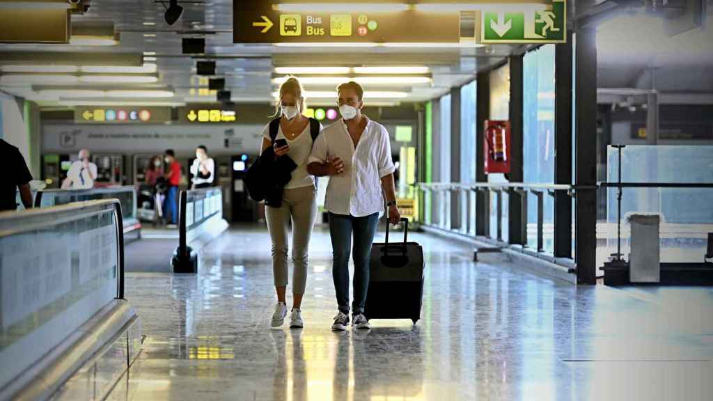 Varios turistas caminan por la terminal 4 del Aeropuerto de Barajas en Madrid.