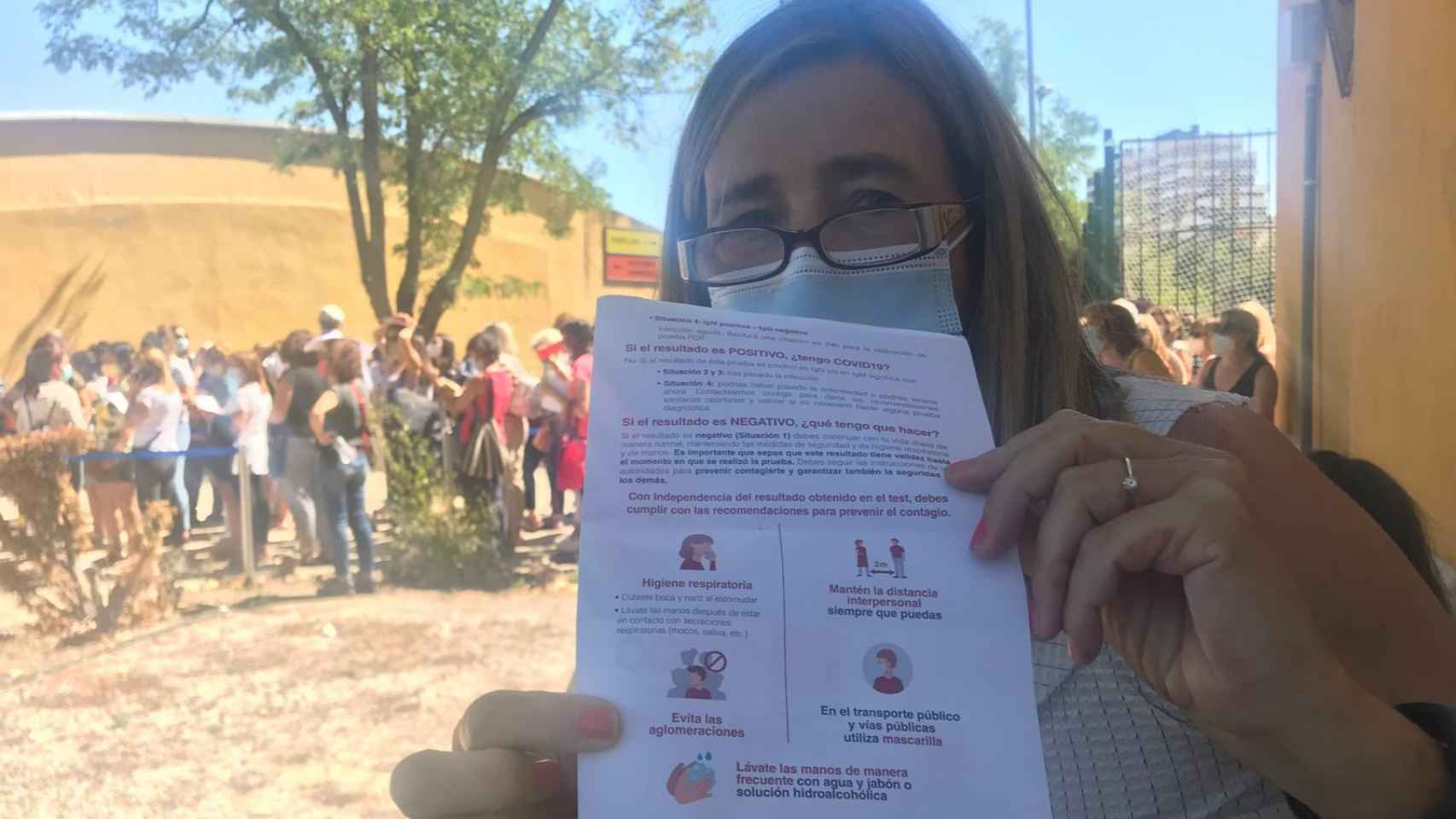 Una profesora muestra el folleto en el que se les pide que eviten aglomeraciones