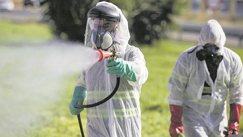Personal fumigando para combatir el mosquito que causa el virus del Nilo.