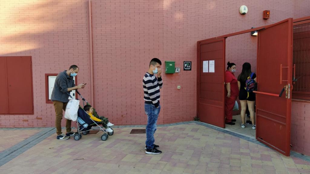 Los padres hacen cola, con distancia de seguridad, para poder acceder a la Escuela Infantil.