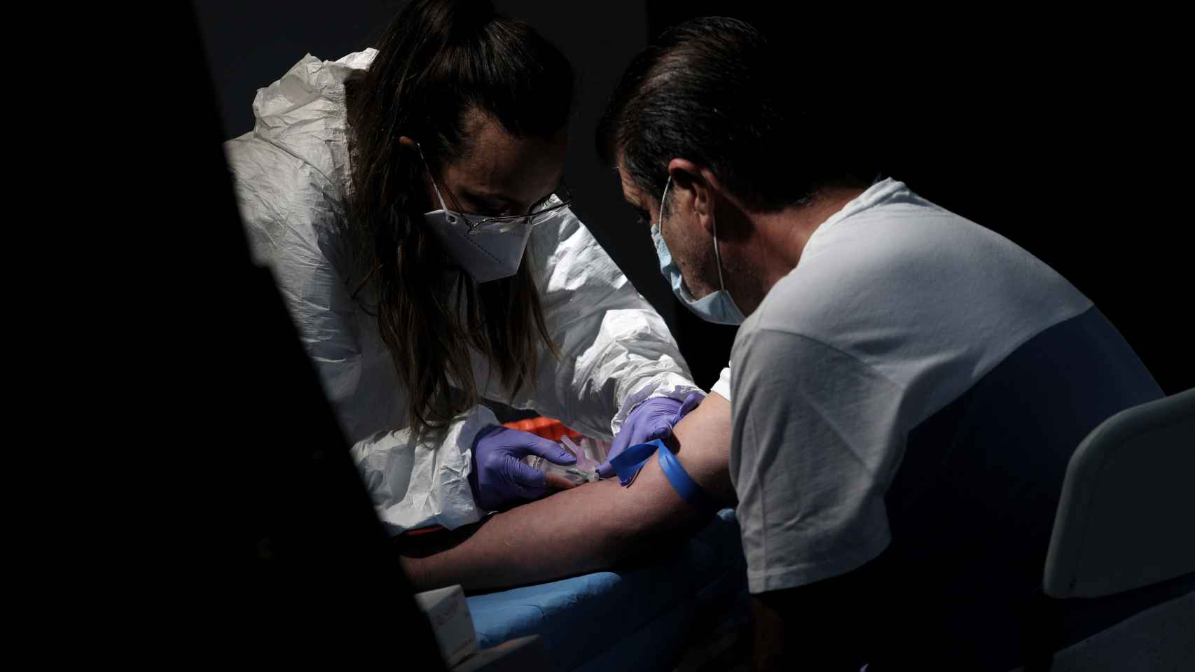 Un sanitario saca sangre a un hombre en el Centro de las Artes Auditorium Municipal de Arroyomolinos, Madrid.